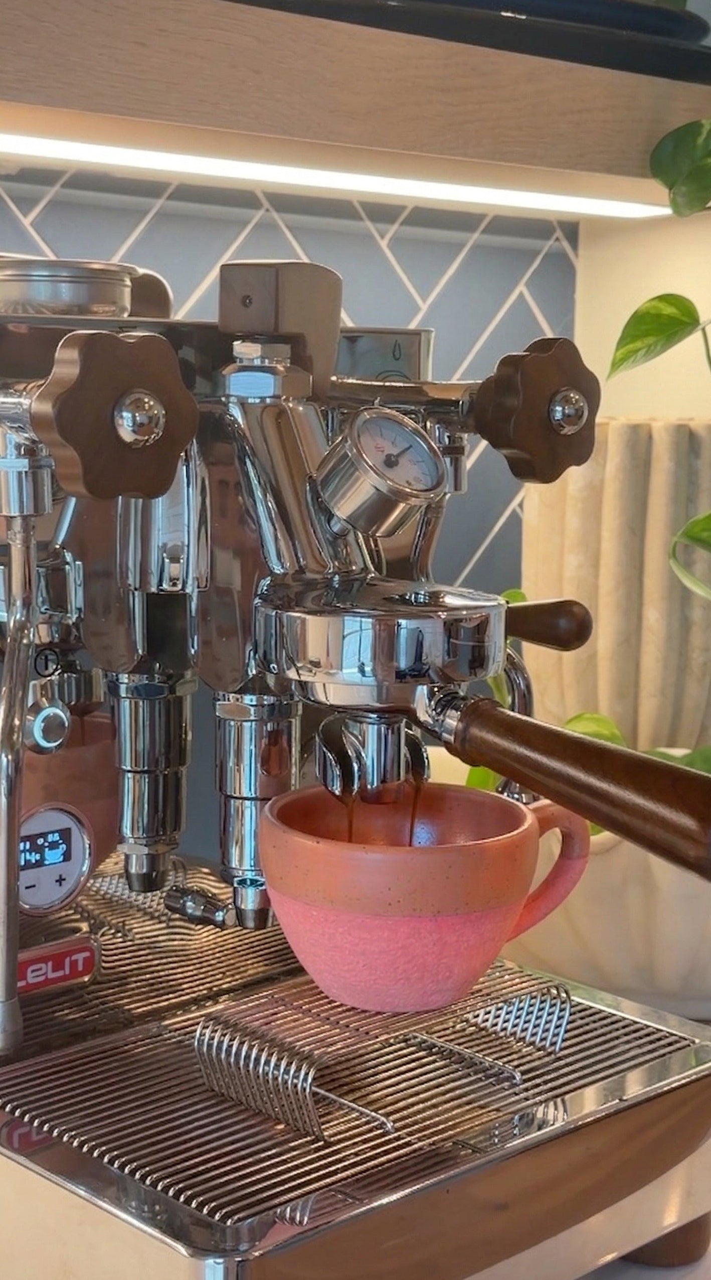 Espresso machine with a coral ceramic cup on a kitchen counter