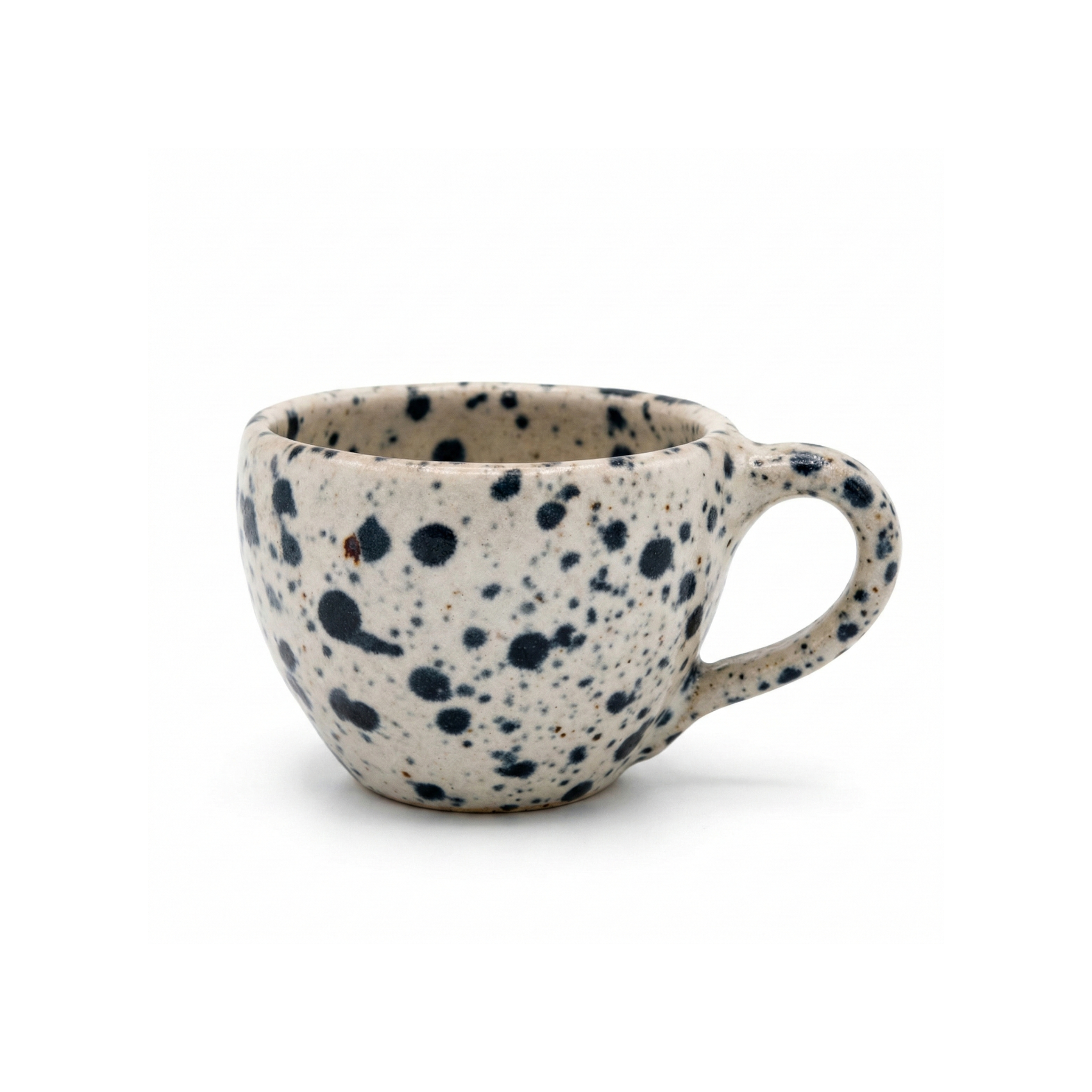 Handmade 10 oz ceramic mug featuring a bold black speckled pattern, side profile view on white background.